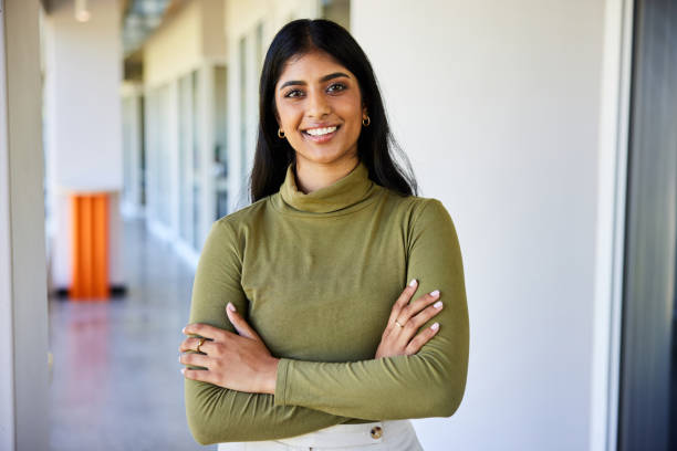 smiling-young-businesswoman-standing-in-the-corridor-of-an-office_jpg